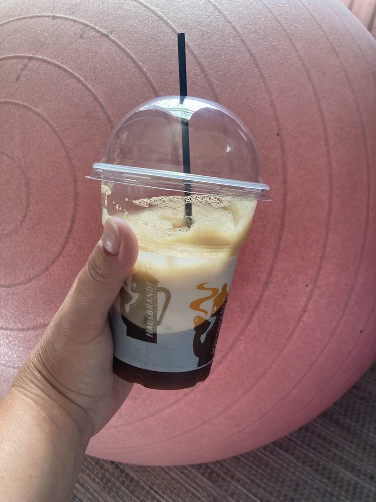 A layered iced coffee in a domed clear cup.